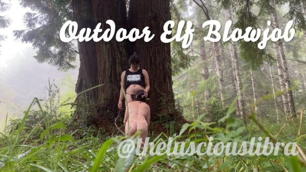 Sofia Verga standing against a redwood while Kathrine Bush kneels to kiss her thigh, text reads "Outdoor Elf Blowjob