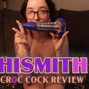 Kathrine Bush holding up a multicolored alligator dildo