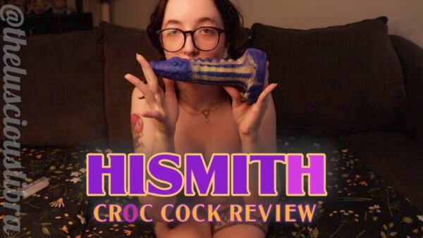 Kathrine Bush holding up a multicolored alligator dildo