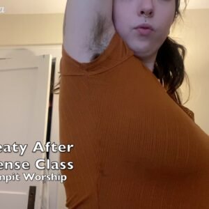 Bodacious brunette wearing tight orange t-shirt showing off her fuzzy armpits. Title reads "Sweaty After Self Defense Class (Hairy Armpit Worship)"